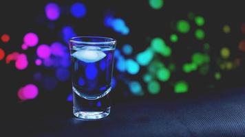 Drink shot in bar on color abstract background photo