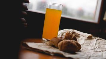 Freshly baked croissants with orange juice on kraft paper photo