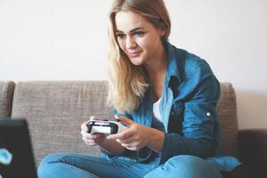 Girl gamer plays with wireless gamepad photo