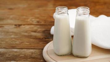 Fresh milk in two glass bottles. Wood rustic background
