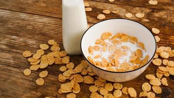 Healthy eating background. Fresh milk in bowl with cornflakes photo