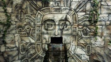 Stone wall in the jungle. Head mask and waterfall from the mouth photo