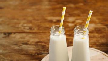 Two bottles of organic rustic milk on wooden table photo