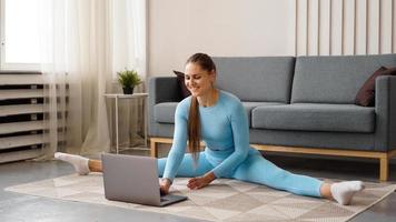 A beautiful woman in a blue tracksuit is stretching photo
