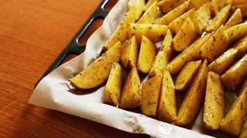 Sliced raw potatoes on a baking sheet with spices photo