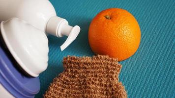 loción, naranja, esponja de ducha y masajeador anticelulítico foto