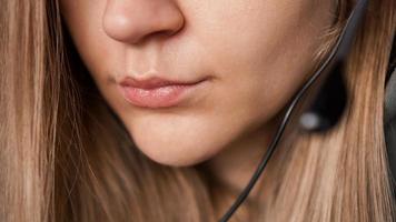 retrato de detalle de labios femeninos y auriculares negros. centro de llamadas foto