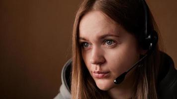 Portrait of a young girl in a hoodie and with a headset photo