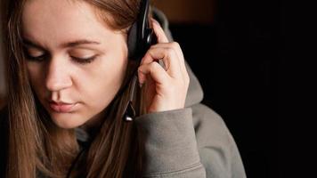 Portrait of a young girl in a hoodie and with a headset