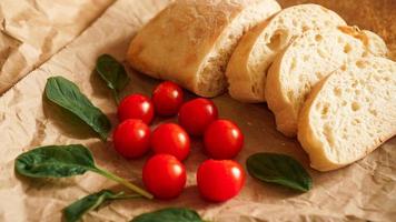 Ciabatta slices and cherry tomatoes on craft paper. photo