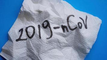Crumpled napkin with 2019-nCoV virus on blue background photo