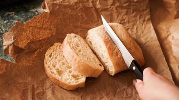 The chef slices the ciabatta with a knife. photo