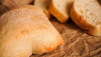 Ciabatta slices on craft paper. Fresh delicious pastries. photo