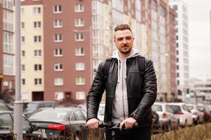 Modern man riding electric scooter in the city photo