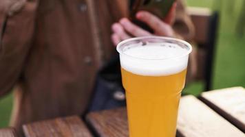 cerveza light en un vaso de plástico. niña bebiendo cerveza en el patio de comidas foto