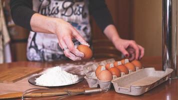 las manos de una chef recogiendo un huevo foto