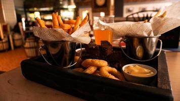 cerveza conjunto de bocadillos en una bandeja de madera. merienda para amigos en una brasserie foto