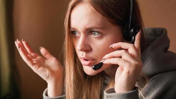 operador de chica confundida con auriculares. trabajo remoto foto