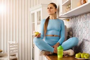 hermosa mujer joven sentada en la cocina foto