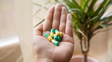 pastillas en mano, tomando su medicación. foto