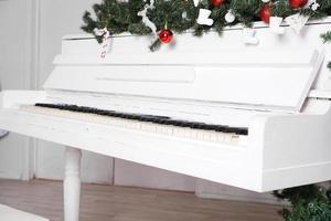 Keys on white upright piano with christmas decor photo