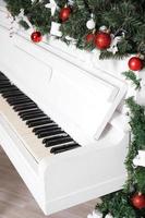 Keys on white upright piano with christmas decor photo