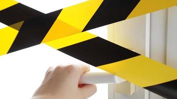 Coronavirus yellow tape Stay home. A hand reaches for the door handle photo
