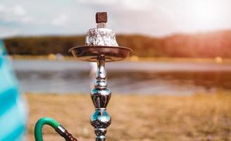 Hookah bowl stands in nature by the river close up photo