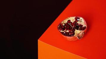 Pomegranate fruit on a black and red background photo