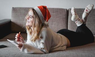 Portrait of pretty girl at Christmas writes plans for the new year