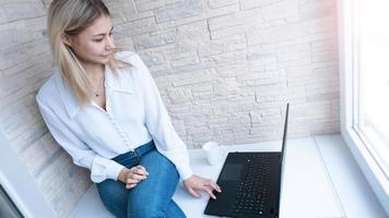 vista lateral. mujer de negocios joven con una taza de café y un cuaderno. foto