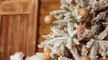 Árbol de Navidad plateado con bolas de oro sobre fondo de madera