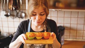 Woman smelling the taste of her homemade muffins photo