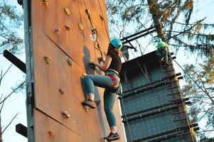 Active young woman on rock wall in sport center photo