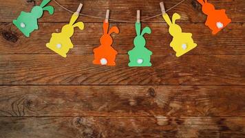 Easter background. Garland of paper rabbits on a wooden background. photo