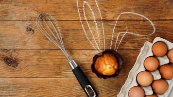 Homemade muffin with painted rabbit ears. Muffin and eggs on a wooden photo