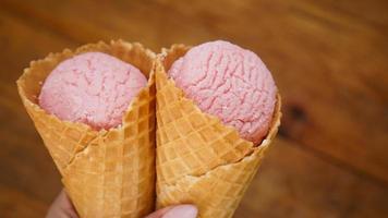 Close up image of woman hand holding two raspberry ice cream photo