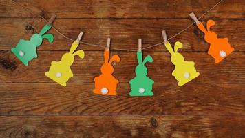 Easter background. Garland of paper rabbits on a wooden background. photo