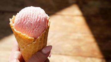 Close up image of woman hand holding two raspberry ice cream photo