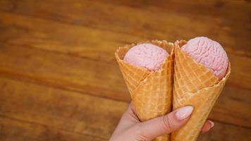 Close up image of woman hand holding two raspberry ice cream photo