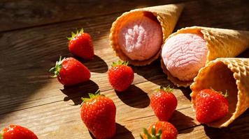 helado de fresa en un cono de galleta. frutos rojos y bolas de helado foto