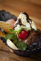 Gourmet organic chocolate and strawberry ice cream sundae dessert with cherry and banana