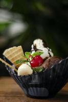 Gourmet organic chocolate and strawberry ice cream sundae dessert with cherry and banana