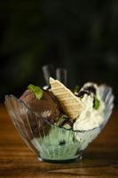 Chocolate and mint fresh organic ice cream sundae dessert on wooden table photo