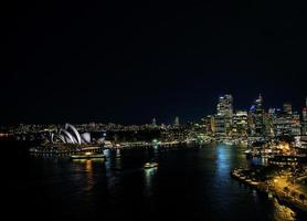 El puerto de la ciudad de Sydney con el horizonte histórico de la ópera en la noche en Australia foto