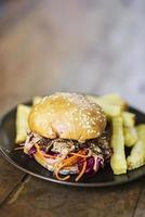 Gourmet pulled pork and pickled vegetables sandwich with french fries