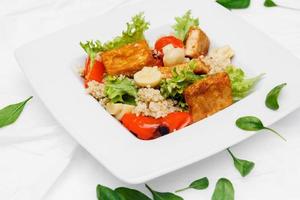 Platos blancos con ensalada, espinacas, aceitunas sobre fondo blanco. foto