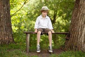 Fair-haired boy in a hat, shirt, shorts photo