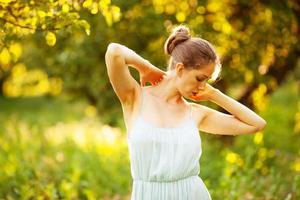 Young woman in a dress in the rays of the evening sun photo