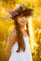 Happy cute girl wearing a wreath of flowers photo
